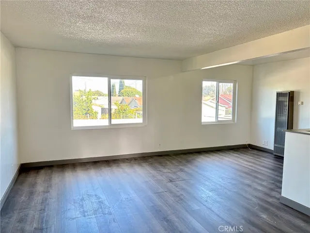 a view of an empty room window and wooden floor