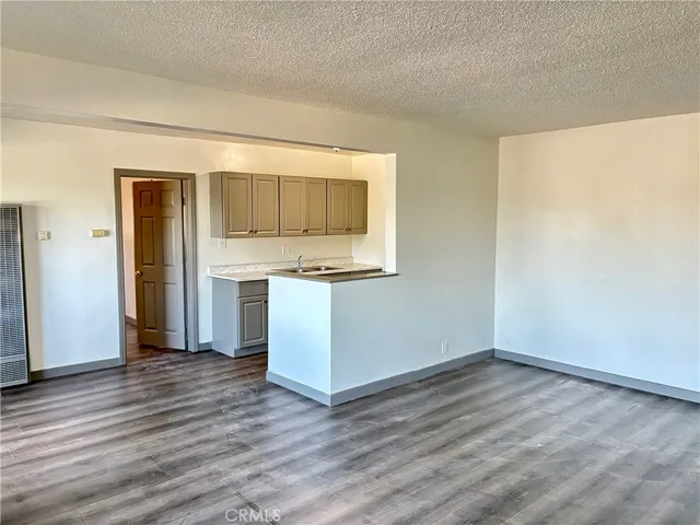 a view of kitchen with wooden floor and electronic appliances