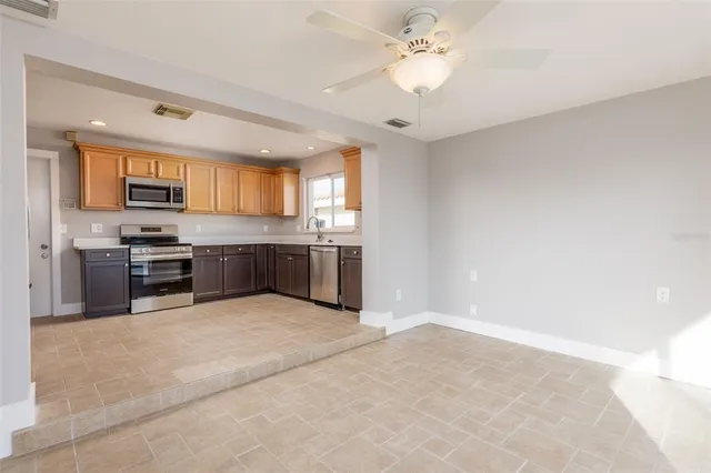 a large kitchen with stainless steel appliances granite countertop a stove and cabinets