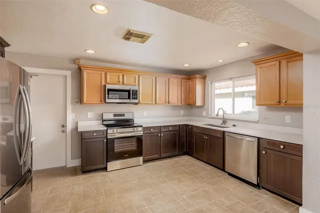 a kitchen with granite countertop stainless steel appliances cabinets and a sink
