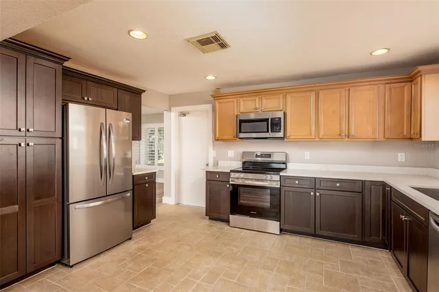 a kitchen with stainless steel appliances granite countertop a refrigerator stove and sink
