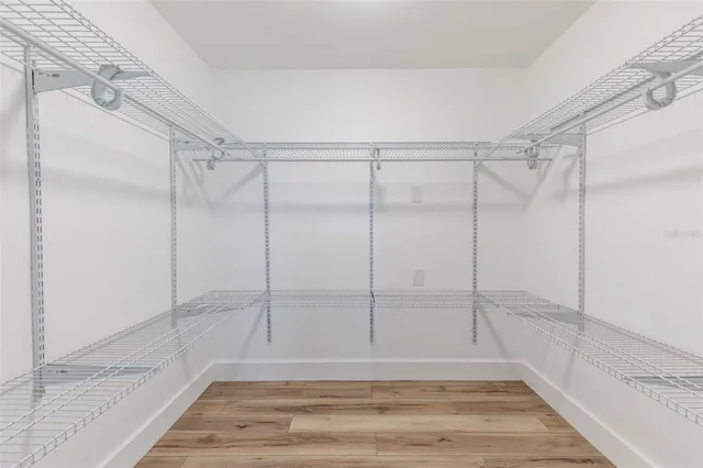 a view of a room with wooden floor and white walls