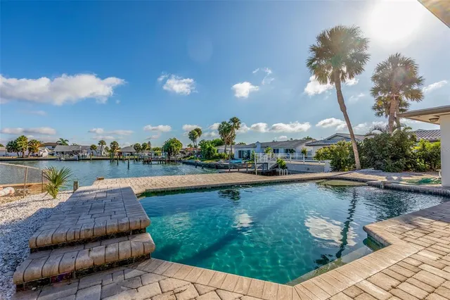 a view of swimming pool with outdoor seating and lake view