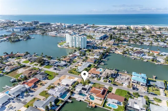 an aerial view of ocean and residential houses with outdoor space