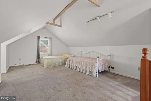 a spacious bedroom with a bed and a night stand