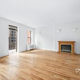 a view of an empty room with a fireplace and a window