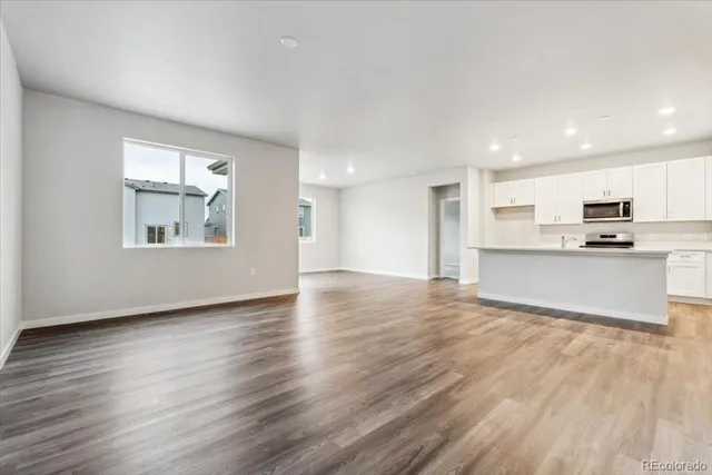 a view of a kitchen with wooden floor and a kitchen