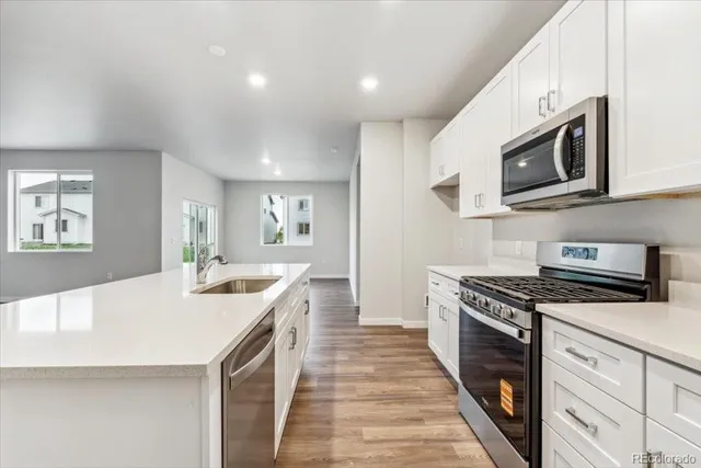 a kitchen with stainless steel appliances granite countertop a sink and stove top oven