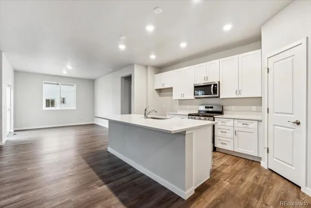 a kitchen with white cabinets and appliances