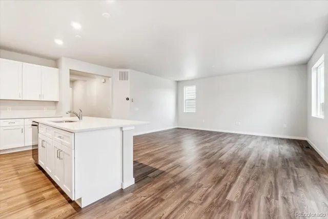 a kitchen with wooden floors and white cabinets