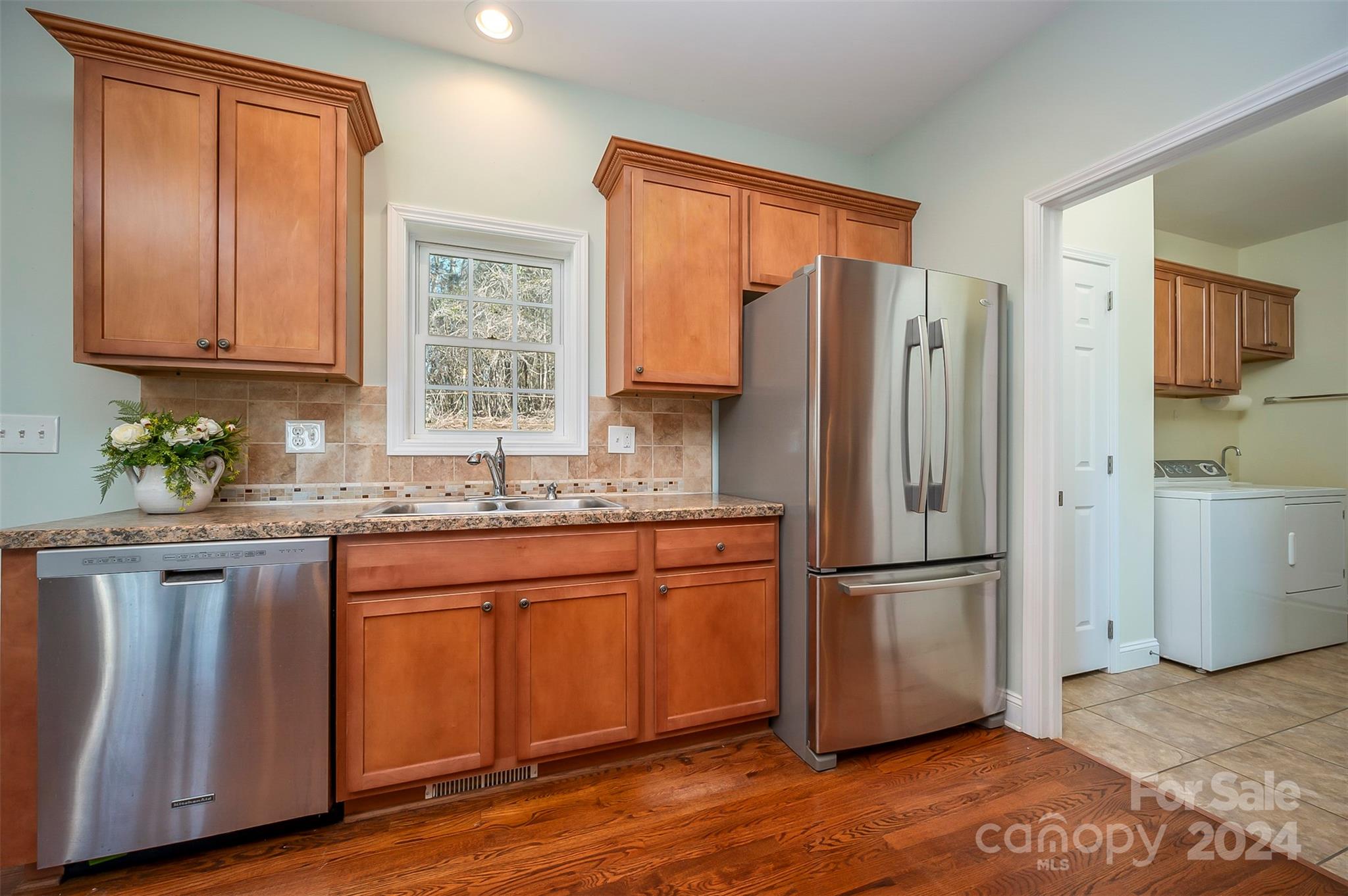 1975 Whiteside Road Mill Spring, NC 28756 - Photo 18 of 37 a kitchen with granite countertop wooden floors white cabinets and stainless steel appliances
