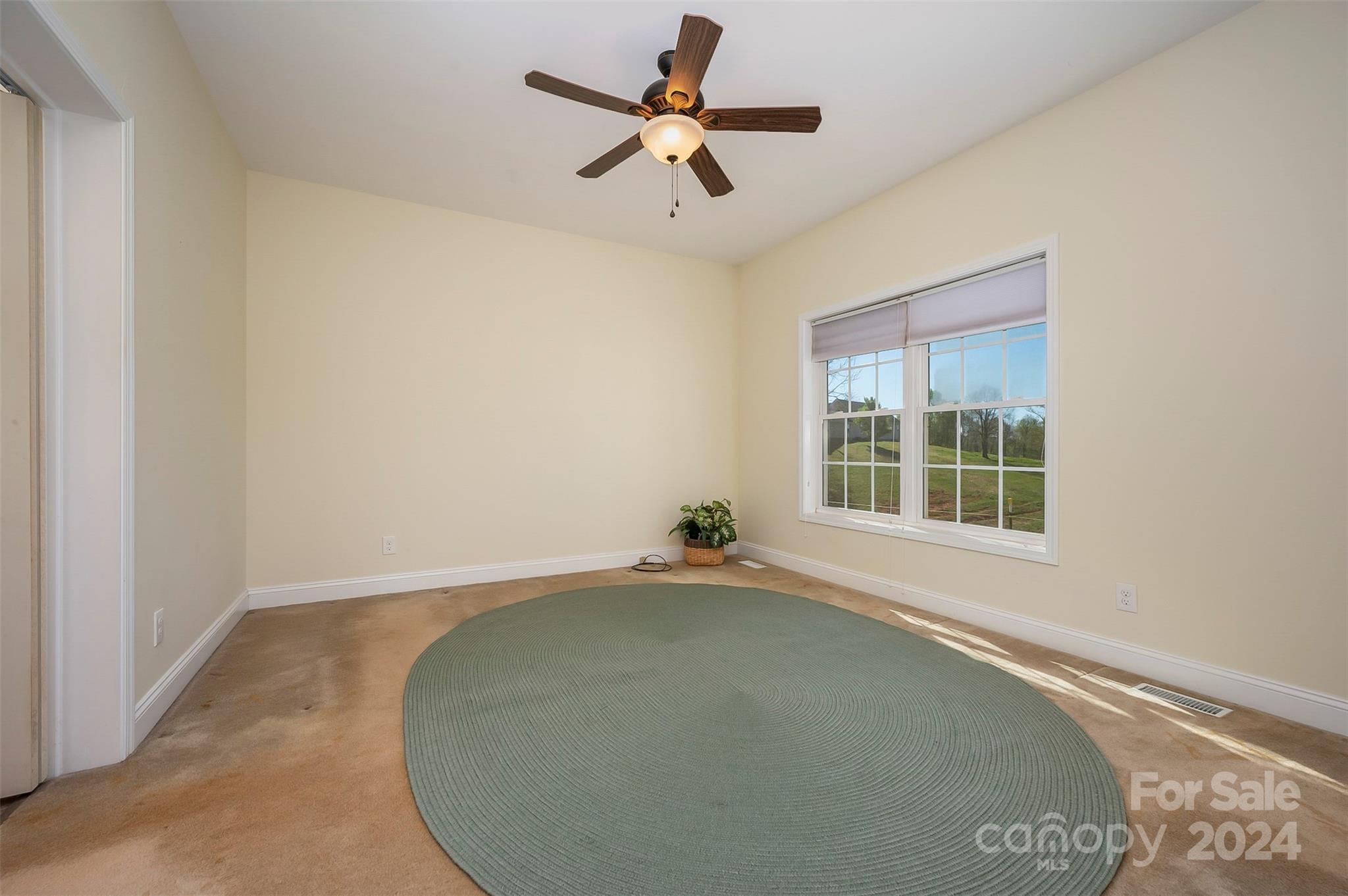 1975 Whiteside Road Mill Spring, NC 28756 - Photo 19 of 37 an empty room with a window and a ceiling fan
