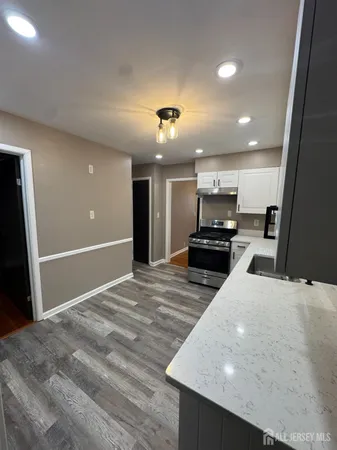 a large kitchen with kitchen island a stove a refrigerator a sink and a large mirror
