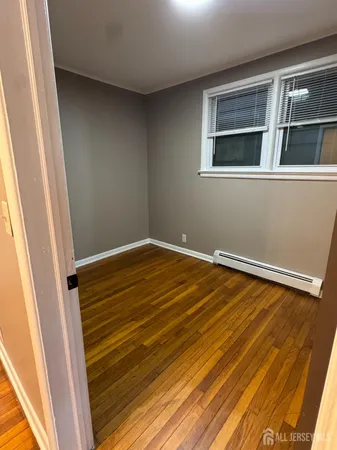 a view of a room with wooden floor and white walls