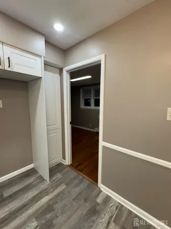 an empty room with wooden floor & windows