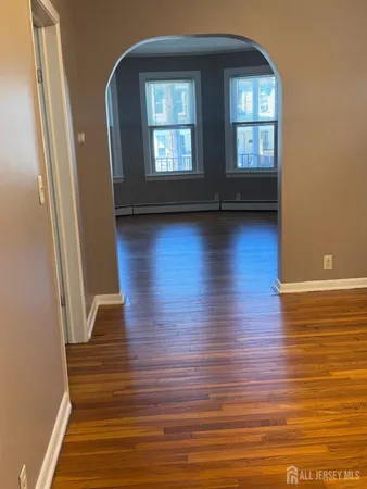 a view of a room with wooden floor and window