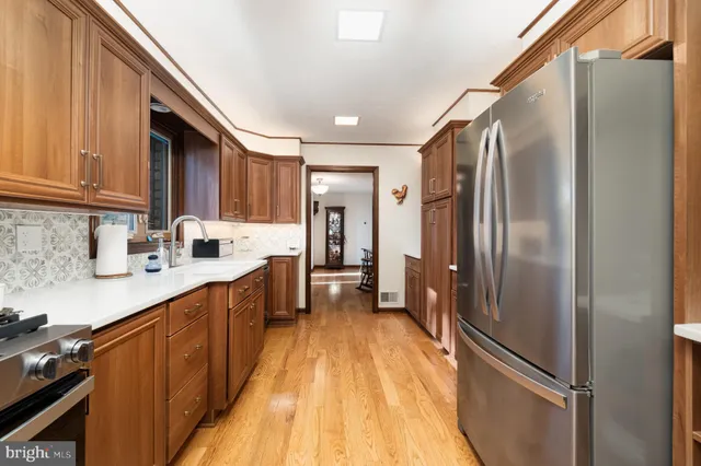 a kitchen with granite countertop wooden cabinets stainless steel appliances and a window