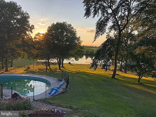 an aerial view of a house with a yard and large trees