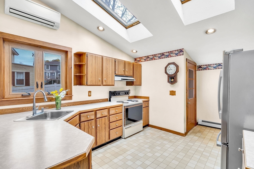 111 Spring Street Marlborough, MA 01752 - Photo 18 of 42 a kitchen with stainless steel appliances granite countertop a refrigerator a stove and a sink with couches
