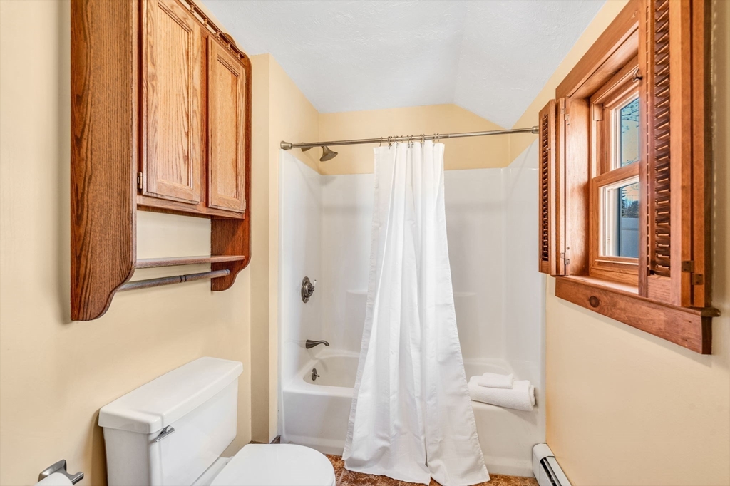 111 Spring Street Marlborough, MA 01752 - Photo 23 of 42 a bathroom with a shower curtain and a toilet