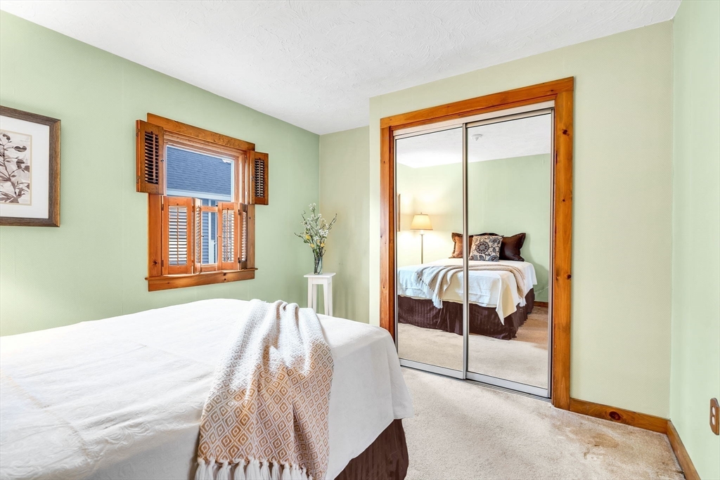 111 Spring Street Marlborough, MA 01752 - Photo 26 of 42 a bedroom with a bed and a large mirror next to a window