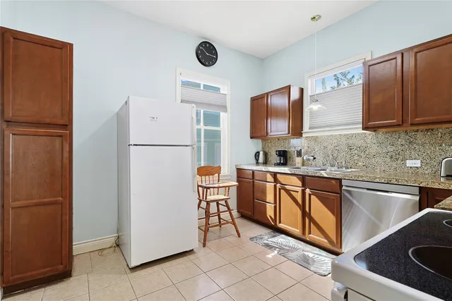 a kitchen with granite countertop cabinets and refrigerator