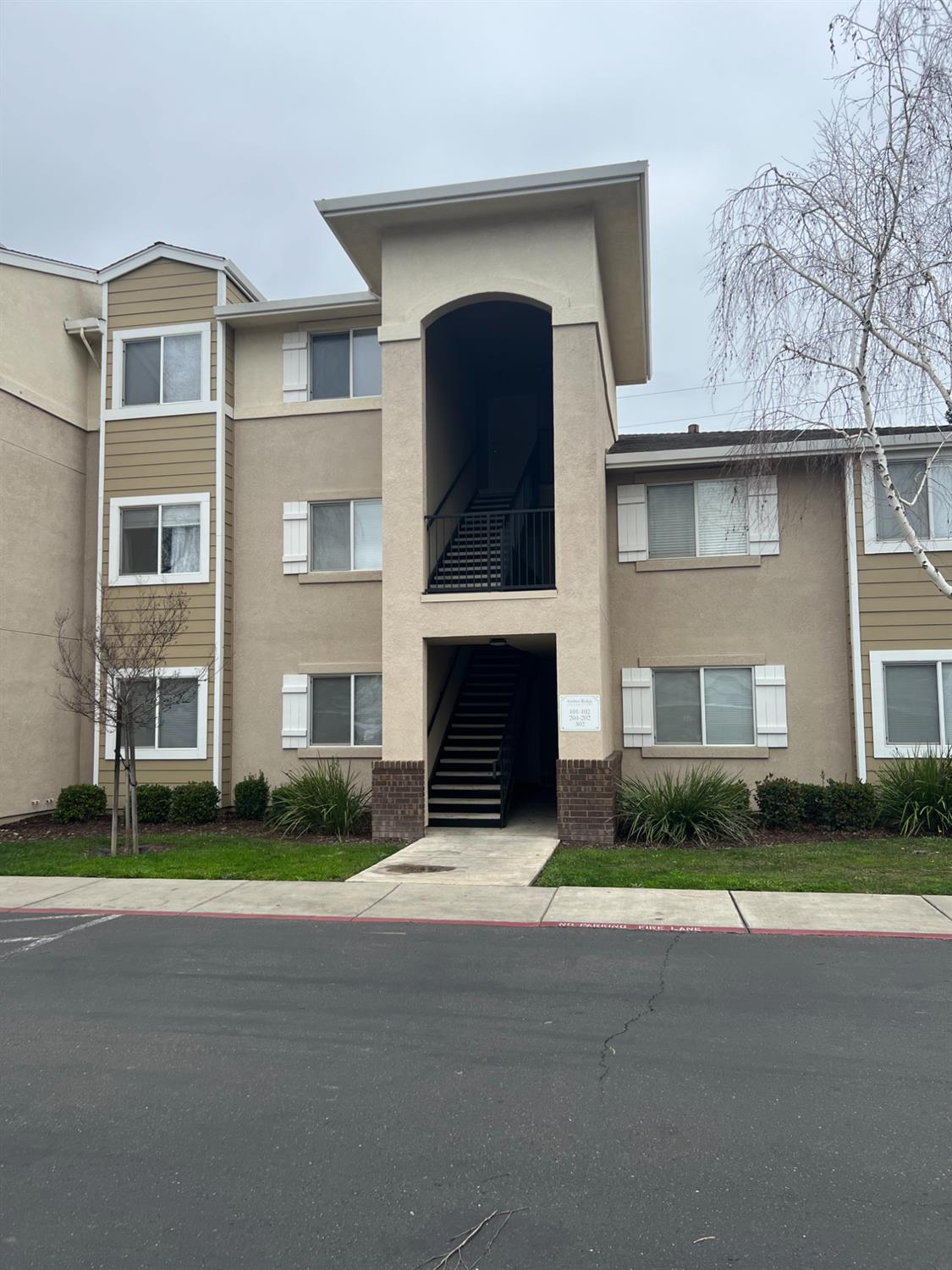 565 Peerless Way, Unit 302 Tracy, CA 95376 - Photo 7 of 17 a front view of a house with a garden and garage