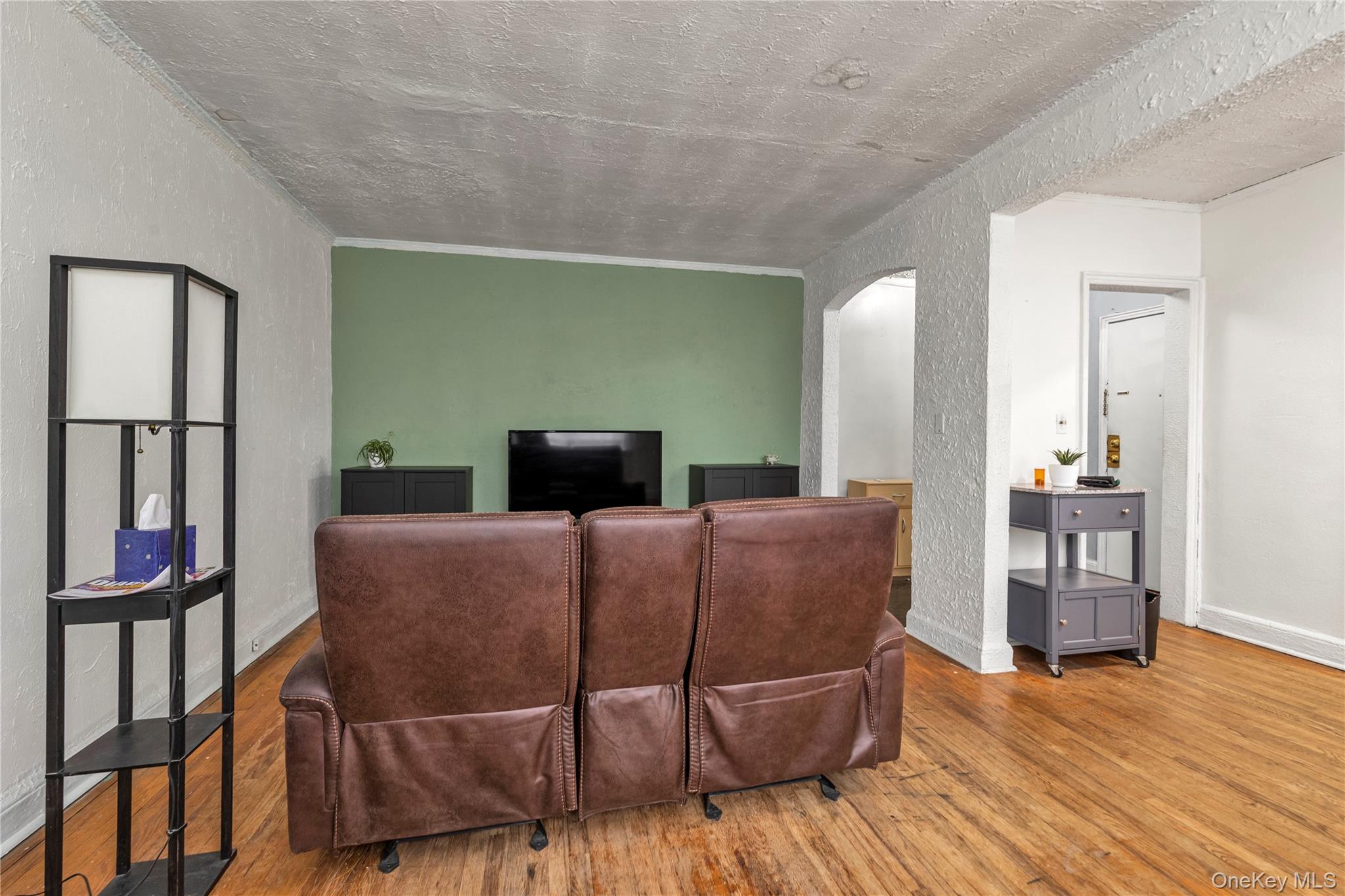 19-54 79th Street, Unit 2 Queens, NY 11370 - Photo 4 of 16 a living room with furniture wooden floor and a flat screen tv