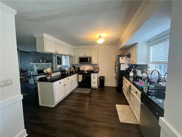 a kitchen with stainless steel appliances a refrigerator and a stove top oven