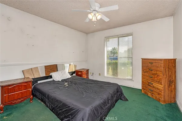 a bedroom with a bed dresser and a window