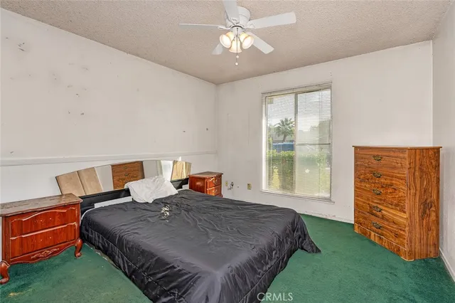 a bedroom with a bed dresser and a window