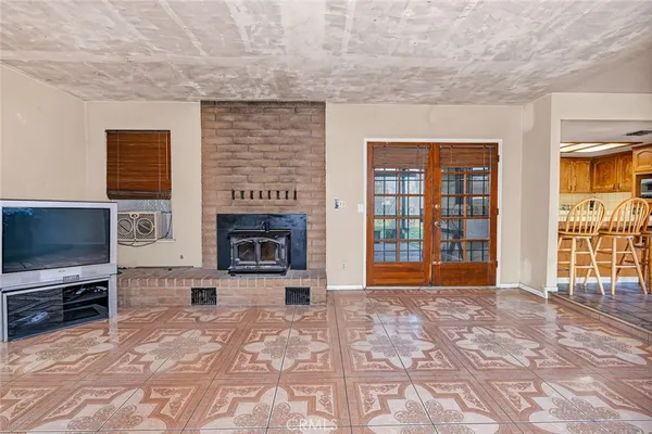 a view of an empty room with a fireplace and a window