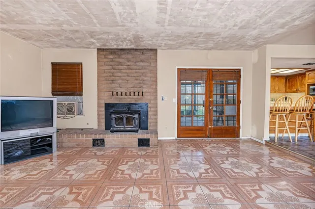 a view of an empty room with a fireplace and a window