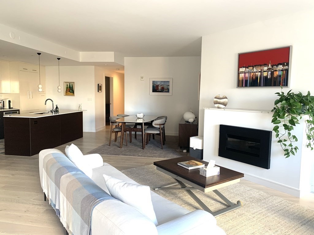 110 Broad Street, Unit 403 Boston, MA 02110 - Photo 1 of 1 a living room with furniture a fireplace and a flat screen tv