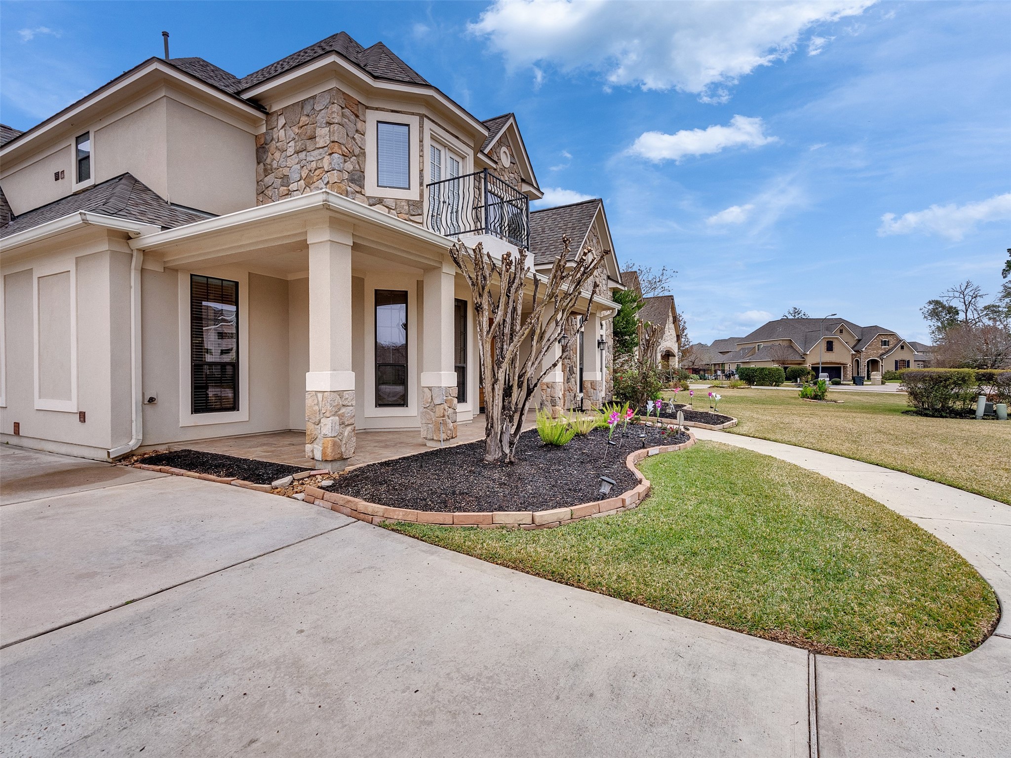 6914 Sandwedge Point Court Spring, TX 77389 - Photo 47 of 50 Modern two-story home with stone and stucco exterior, a covered porch, and well-maintained landscaping. The property features a spacious driveway and a manicured lawn, set in a quiet neighborhood with similar styled homes.