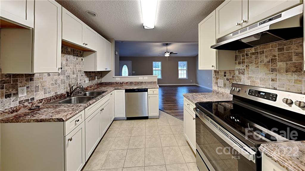 170 State Park Road Troutman, NC 28166 - Photo 4 of 11 a large kitchen with stainless steel appliances granite countertop a stove a sink dishwasher and a microwave