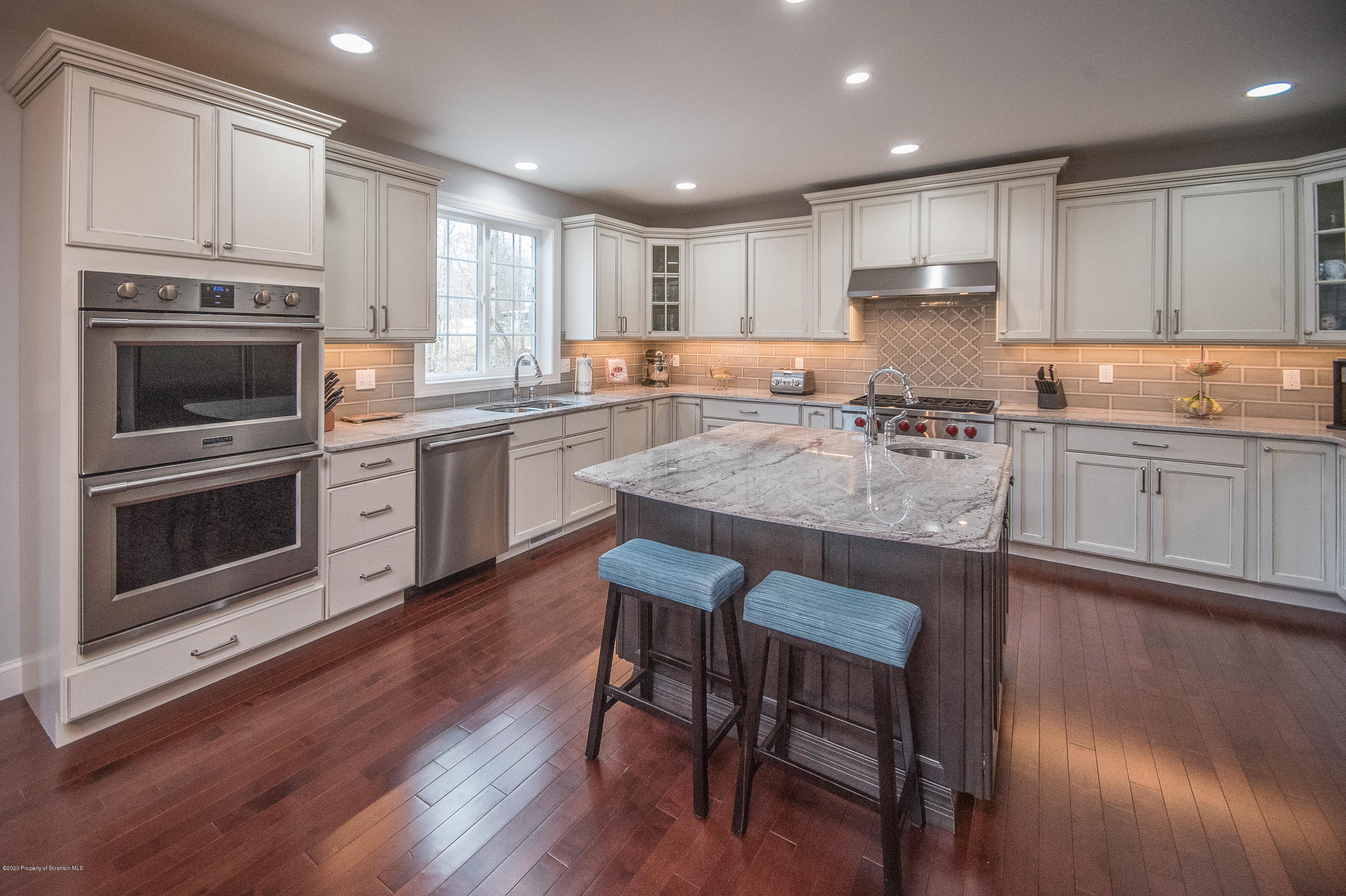 121 Highland Road Moscow, PA 18444 - Photo 18 of 93 a kitchen with stainless steel appliances granite countertop a stove top oven a sink dishwasher a dining table and chairs with wooden floor