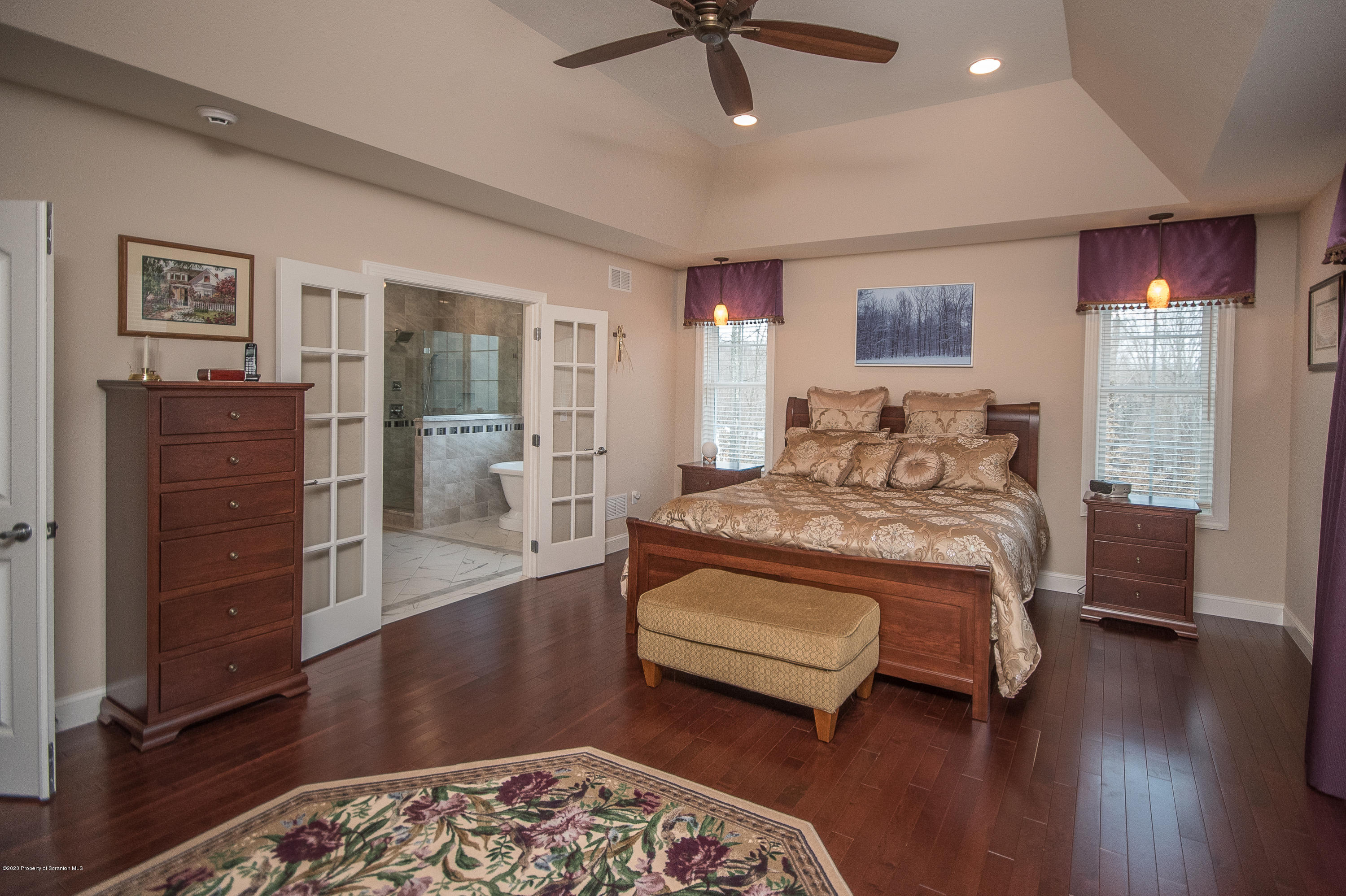 121 Highland Road Moscow, PA 18444 - Photo 48 of 93 a bedroom with a bed and a chandelier