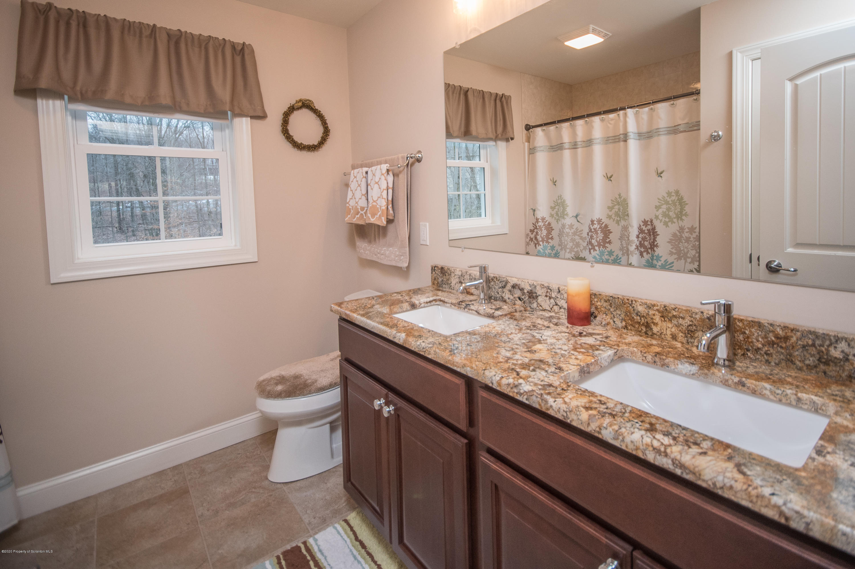 121 Highland Road Moscow, PA 18444 - Photo 72 of 93 a bathroom with a granite countertop sink a toilet and a mirror