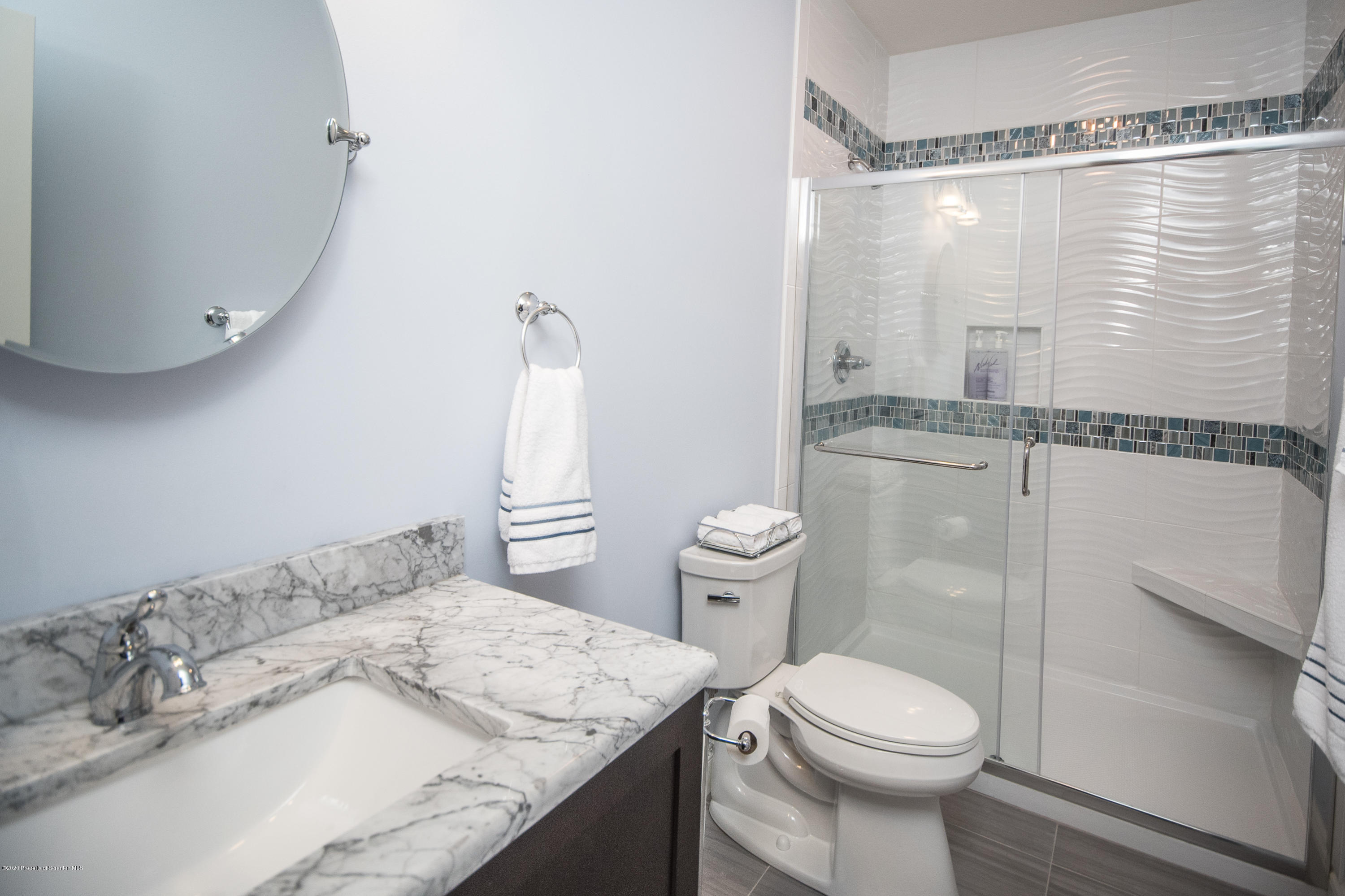 121 Highland Road Moscow, PA 18444 - Photo 75 of 93 a bathroom with a granite countertop sink a toilet a mirror and shower