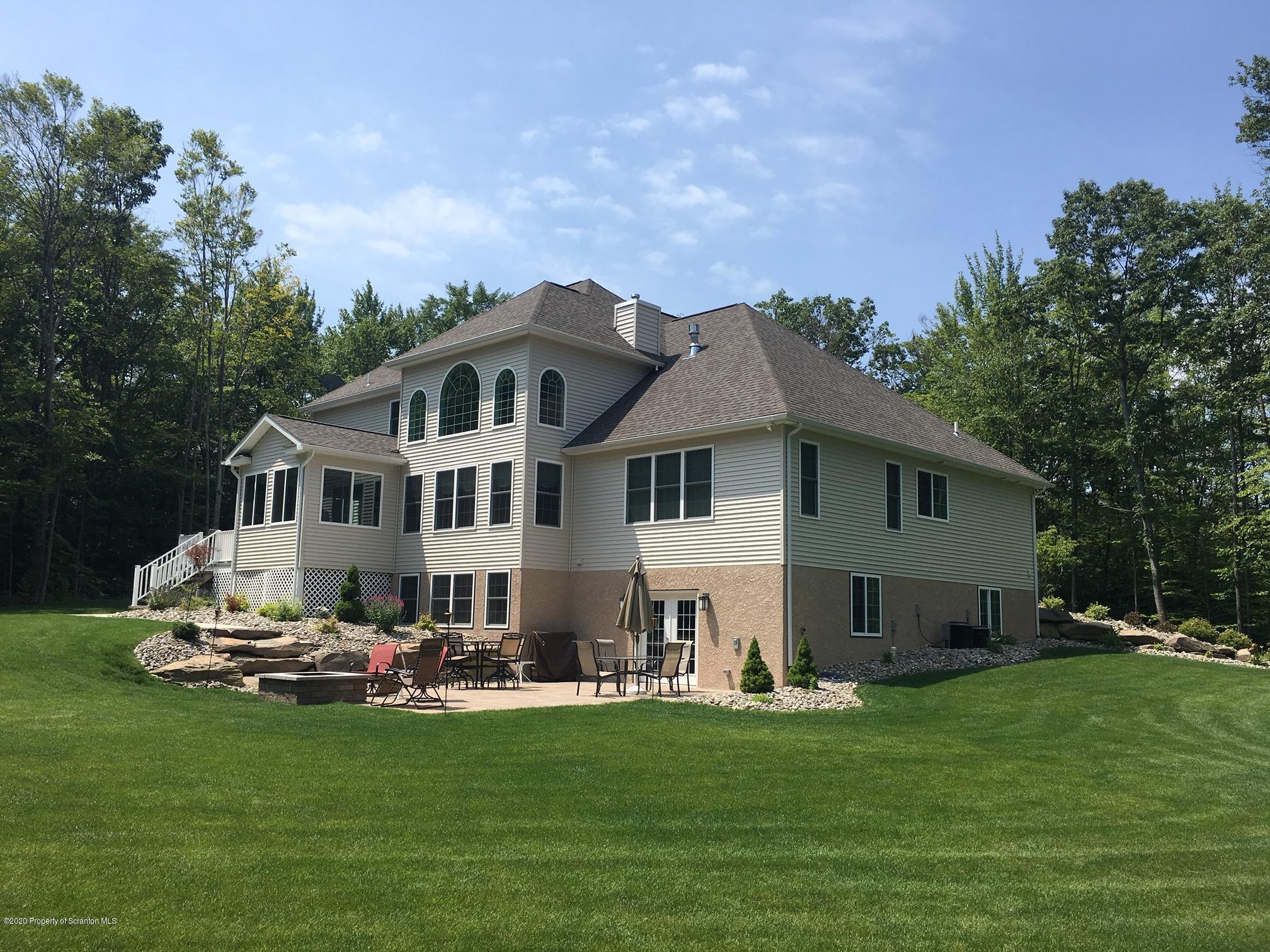 121 Highland Road Moscow, PA 18444 - Photo 85 of 93 a front view of a house with a garden and trees