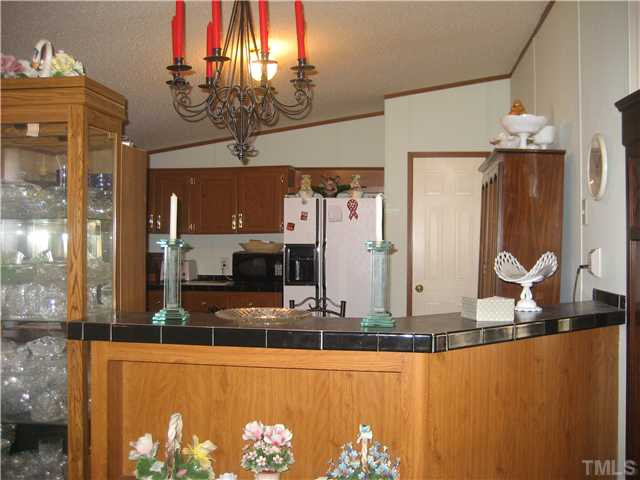 8 Weaver Road Kenly, NC 27542 - Photo 7 of 14 Kitchen with bar and side-by-side Frig conveys.