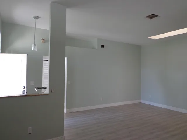 an empty room with wooden floor and mirror