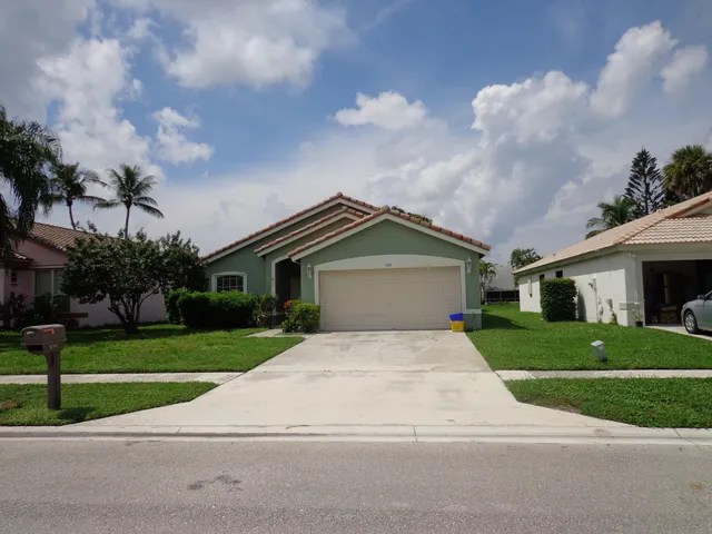 a front view of a house with a yard and trees