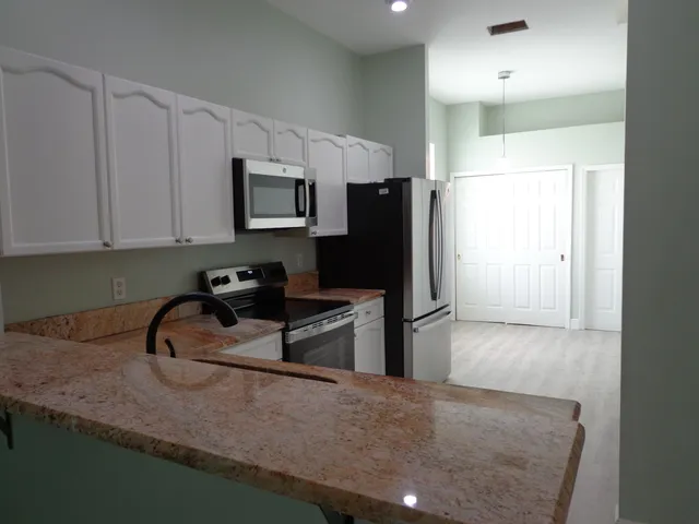 a kitchen with stainless steel appliances granite countertop a sink stove and refrigerator