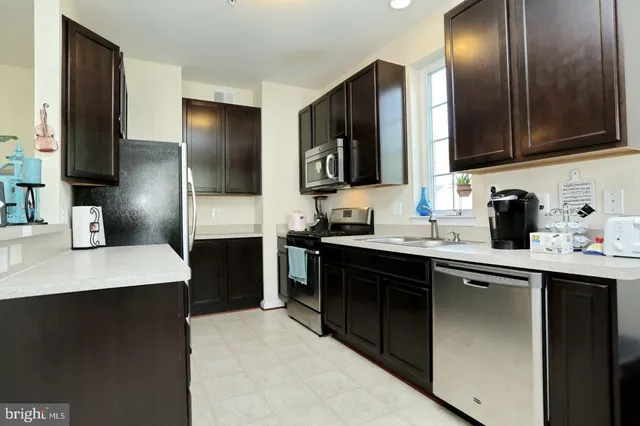 a kitchen with a sink refrigerator and cabinets