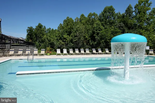 a swimming pool with outdoor seating yard and trees