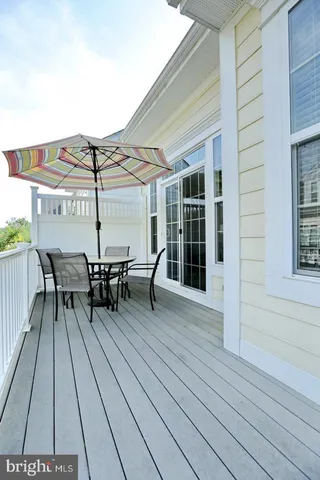 a roof deck with table and chairs and wooden floor