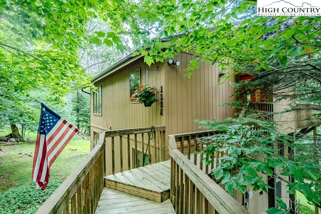 a balcony with wooden floor and outdoor seating