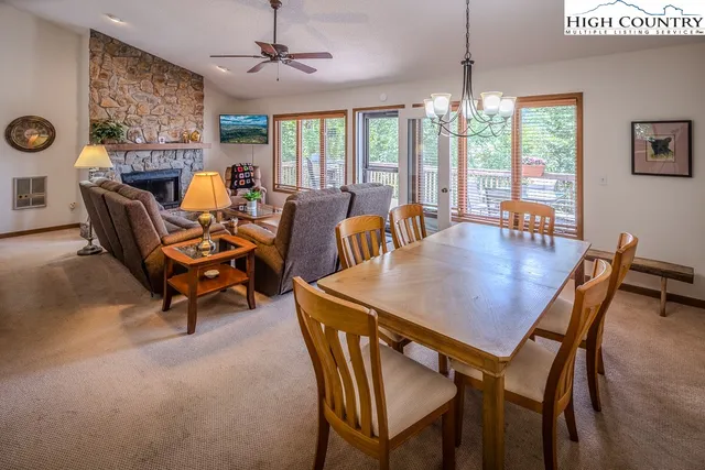 a dining room with furniture a chandelier and window